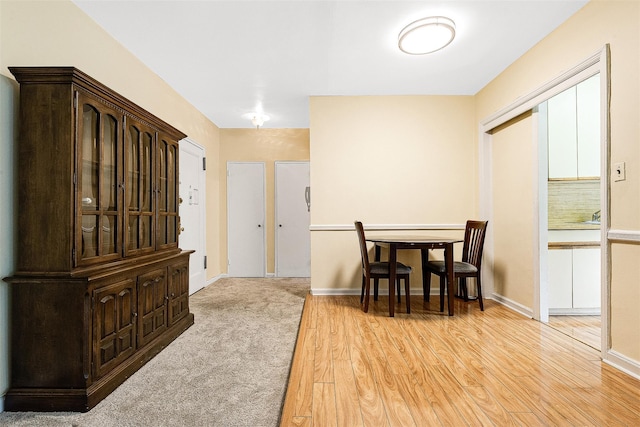dining area featuring baseboards and light wood-style flooring