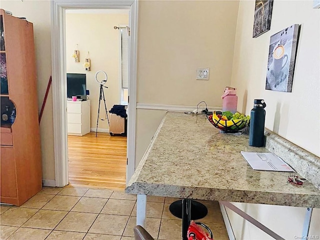 interior space with light tile patterned floors, light countertops, and baseboards