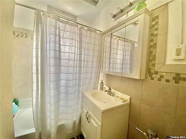 full bath featuring tile walls, vanity, and shower / bath combination with curtain