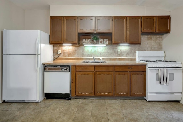 kitchen featuring white appliances, a sink, light countertops, and backsplash