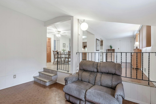 living room featuring tile patterned flooring, baseboards, and ceiling fan