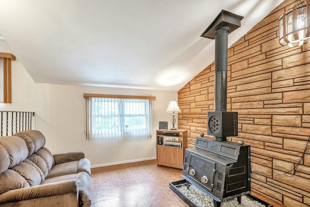living room with a wood stove, light floors, baseboards, and lofted ceiling