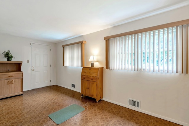 empty room featuring baseboards and visible vents