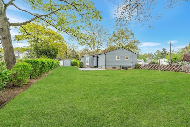 view of yard with a patio area, an outdoor structure, fence, and a shed