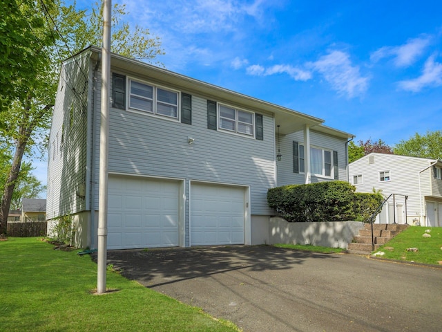 view of front of property with an attached garage, driveway, and a front yard