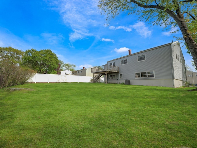 rear view of house with fence, a deck, cooling unit, a lawn, and stairway