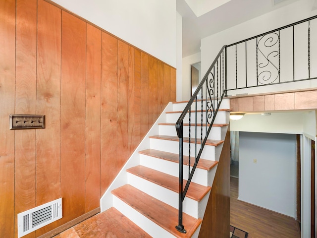 staircase featuring visible vents and wood finished floors