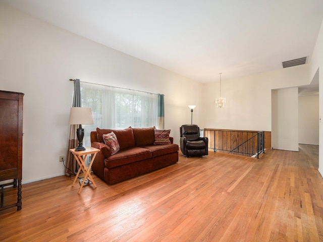 living area featuring visible vents, a chandelier, and light wood-type flooring