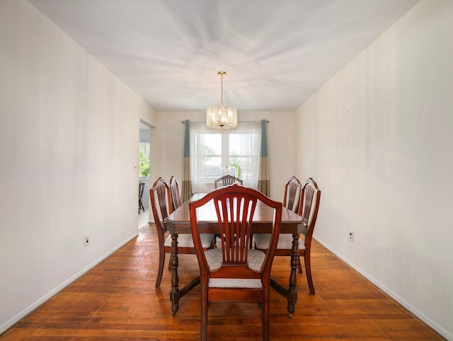 dining room featuring baseboards, wood finished floors, and a chandelier