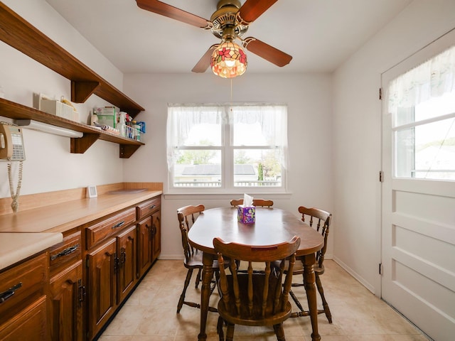 dining room with baseboards, a ceiling fan, and light tile patterned floors
