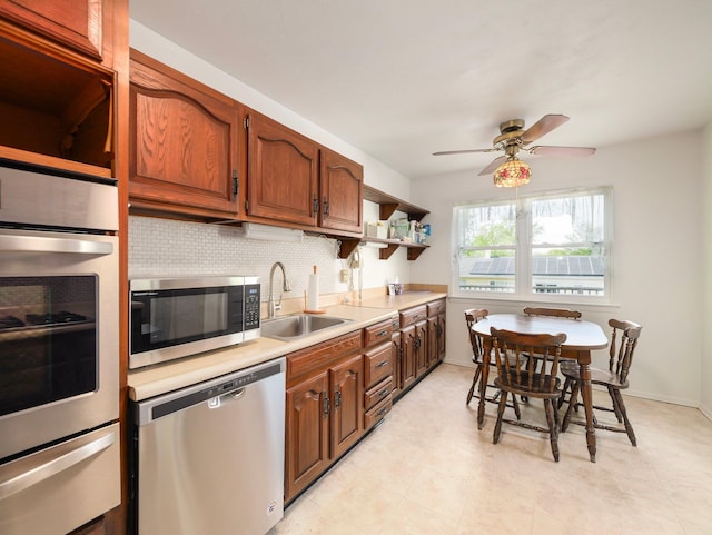 kitchen featuring open shelves, light countertops, a sink, appliances with stainless steel finishes, and a warming drawer