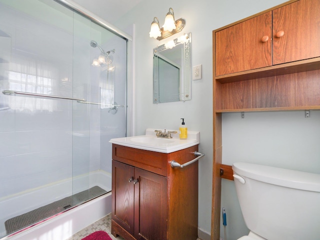 full bath featuring toilet, a shower with door, and vanity