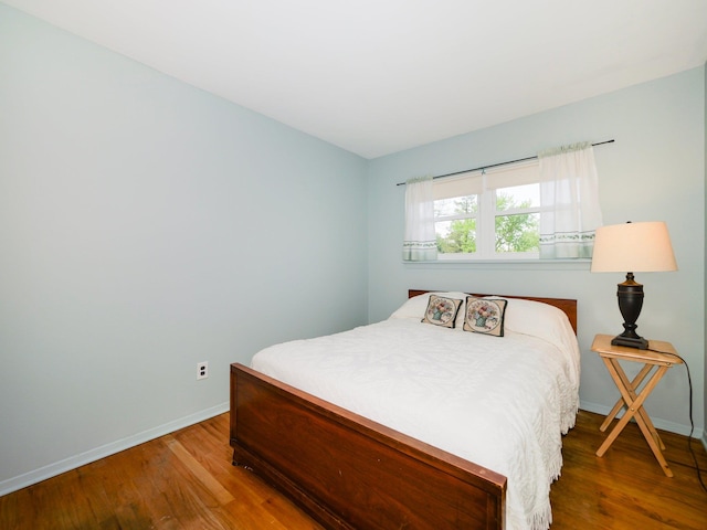 bedroom featuring baseboards and wood finished floors