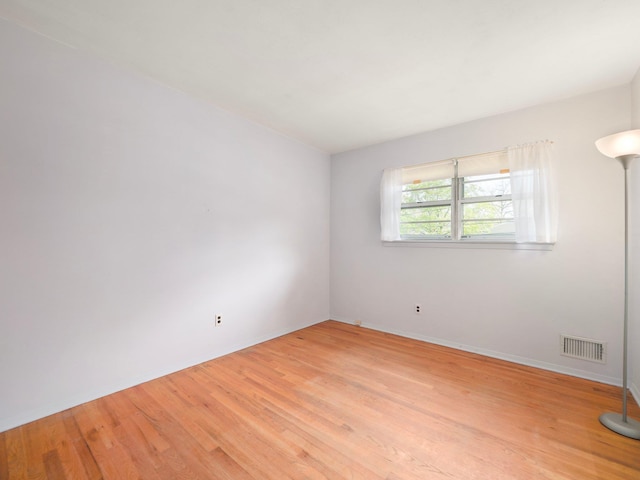unfurnished room with light wood-style floors, baseboards, and visible vents