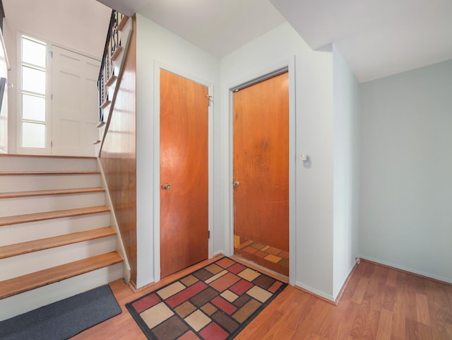 staircase with baseboards and wood finished floors