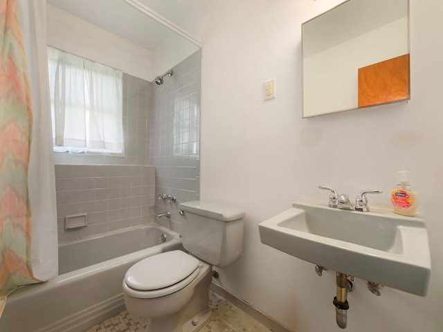 bathroom featuring a sink, shower / bath combo with shower curtain, and toilet