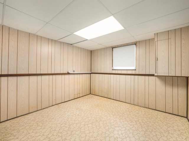 spare room with wood walls and a paneled ceiling