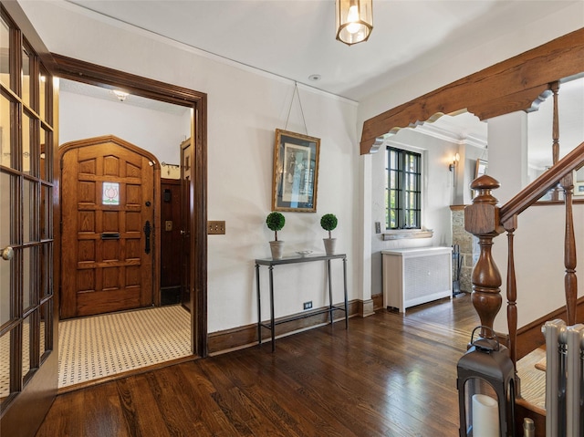 entryway featuring baseboards, radiator heating unit, crown molding, and wood finished floors