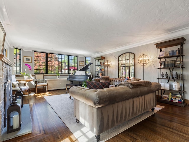living area with a notable chandelier, a fireplace, a textured ceiling, wood finished floors, and ornamental molding