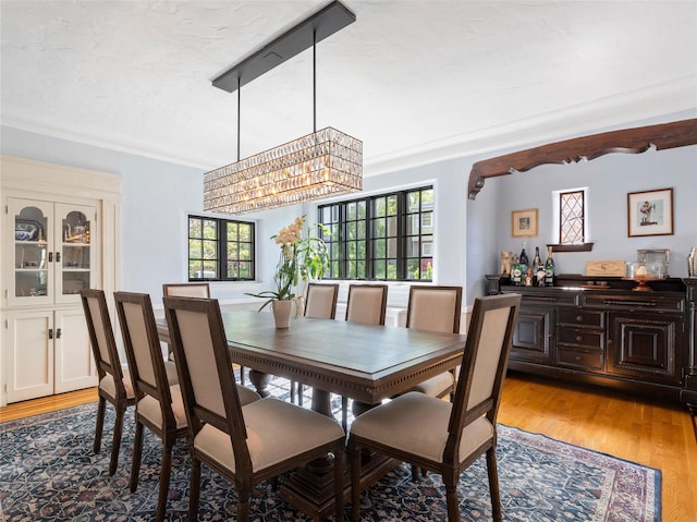 dining area with light wood-type flooring and a notable chandelier