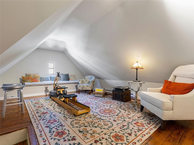 living area featuring a baseboard heating unit, wood finished floors, and lofted ceiling
