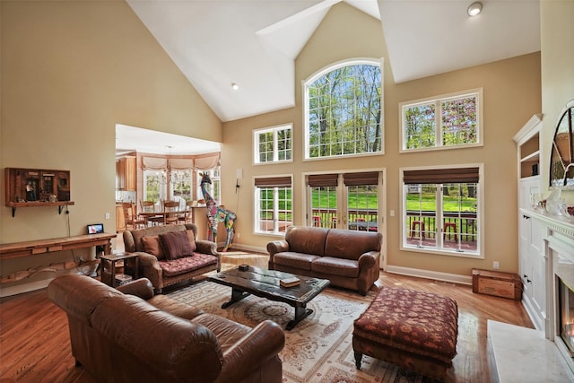living room with high vaulted ceiling, a fireplace, and a wealth of natural light
