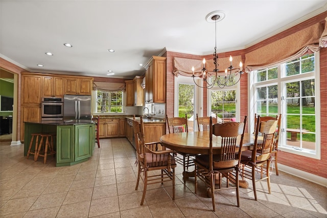 dining space with baseboards, ornamental molding, a notable chandelier, and a healthy amount of sunlight