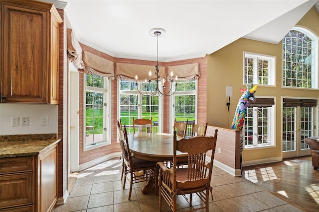 dining area featuring baseboards, a wealth of natural light, and a notable chandelier