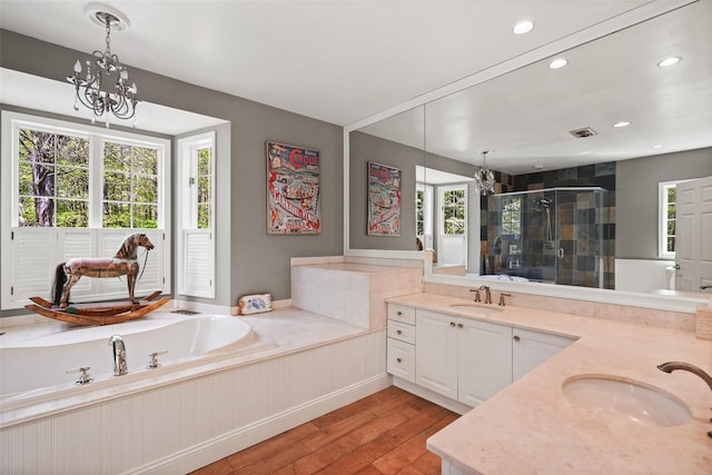 bathroom with a sink, a shower stall, hardwood / wood-style floors, and a wealth of natural light