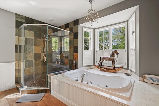 full bath with a tub with jets, a chandelier, and a shower stall