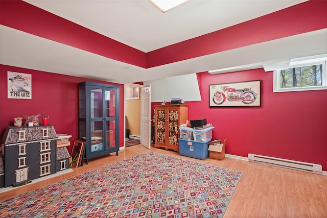 game room featuring baseboards, wood finished floors, and baseboard heating