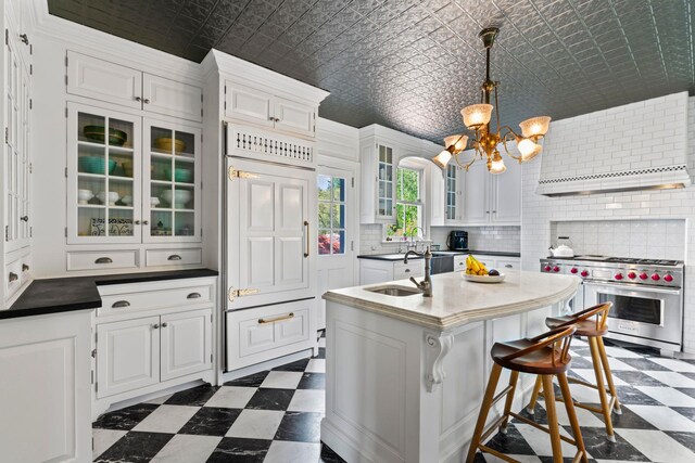381 W Neck Rd, Lloyd Harbor, NY 11743 - kitchen with high end appliances, an ornate ceiling, white cabinetry, dark floors, and a notable chandelier