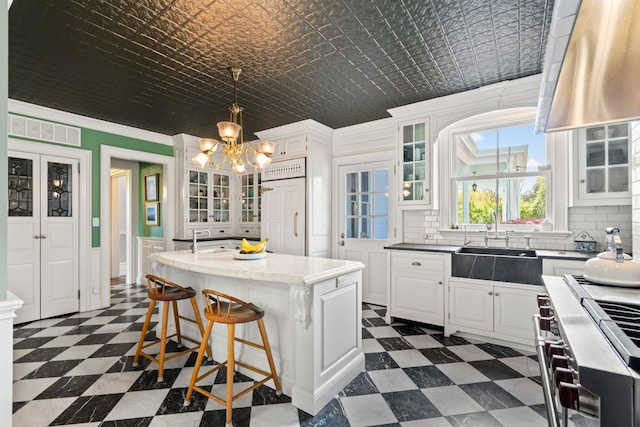 381 W Neck Rd, Lloyd Harbor, NY 11743 - kitchen with high end stove, a sink, dark floors, and an inviting chandelier