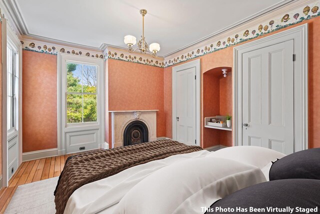 381 W Neck Rd, Lloyd Harbor, NY 11743 - bedroom featuring a notable chandelier, light wood finished floors, baseboards, wallpapered walls, and ornamental molding
