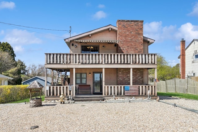 18 Hoppin Ave, Montauk, NY 11954 - view of front of home with fence, a porch, stairway, a chimney, and a balcony