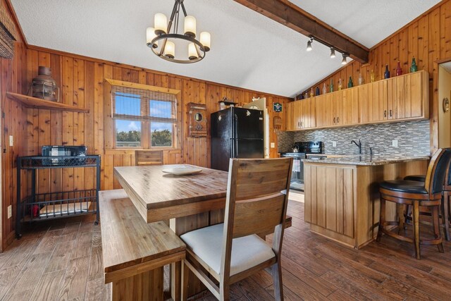 18 Hoppin Ave, Montauk, NY 11954 - kitchen with dark wood finished floors, freestanding refrigerator, a peninsula, a chandelier, and vaulted ceiling with beams