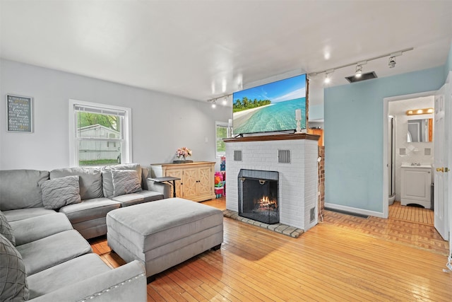2 Random Rd, Greenwood Lake, NY 10925 - living room with track lighting, a fireplace, and wood-type flooring
