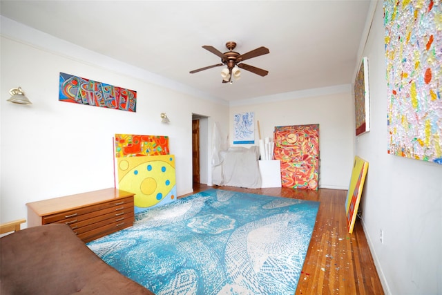 bedroom featuring a ceiling fan, wood finished floors, and baseboards