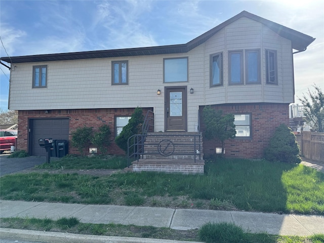 raised ranch with a garage, fence, and brick siding