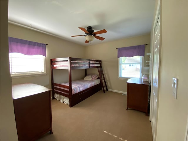 bedroom with baseboards, ceiling fan, and light carpet