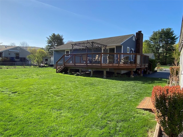 back of house with a lawn, a pergola, a wooden deck, and a chimney