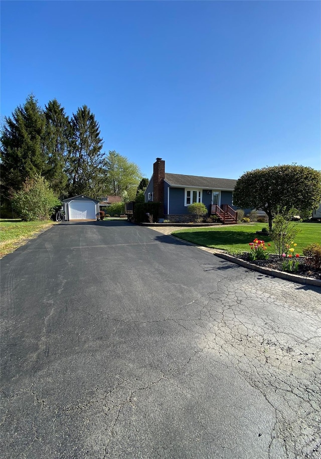 view of front of property with a chimney, a front lawn, and aphalt driveway