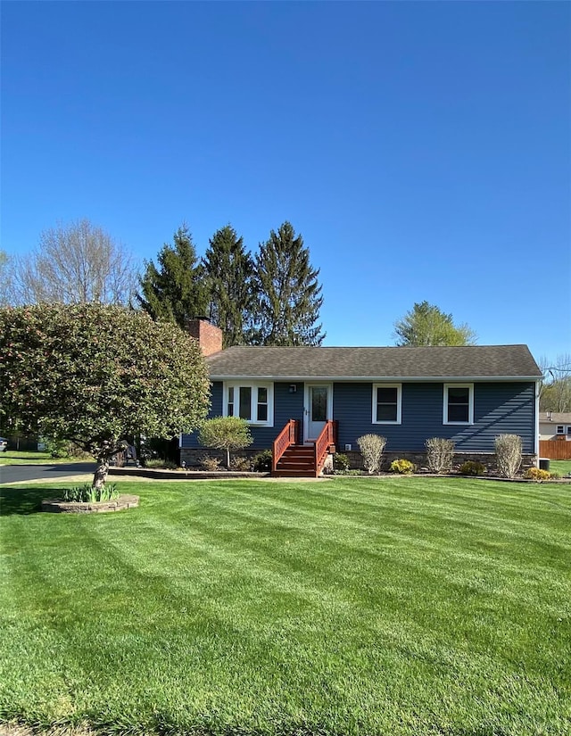 ranch-style home with a chimney and a front lawn