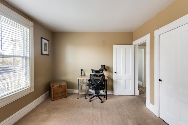 carpeted office space featuring baseboards and a wealth of natural light