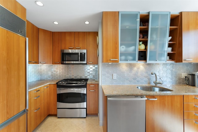 kitchen featuring brown cabinets, a sink, open shelves, stainless steel appliances, and modern cabinets