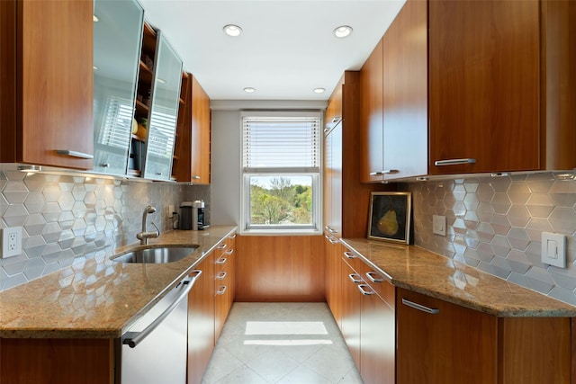 kitchen with white dishwasher, modern cabinets, a sink, and brown cabinets