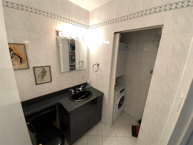 bathroom featuring toilet, tile patterned floors, tile walls, and stacked washing maching and dryer