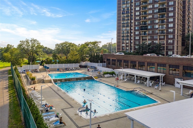 pool with fence and a patio area