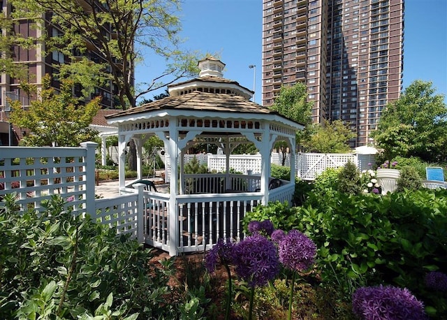 view of property's community with fence and a gazebo