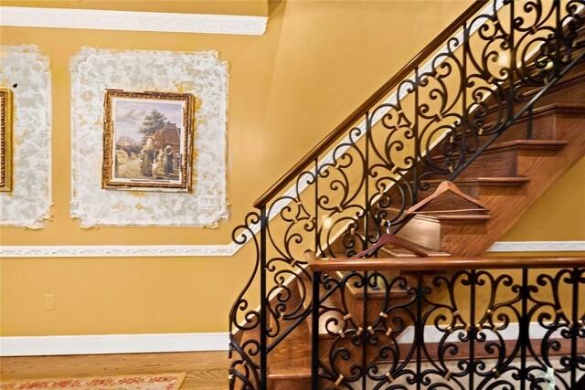 staircase with baseboards and wood finished floors